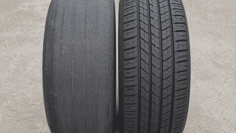 Side-by-side comparison of a heavily worn front tire and a nearly new rear tire from the same front-wheel drive car, showing the dramatic wear difference