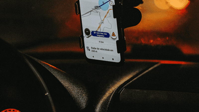 A first-person perspective of a driver using a MagSafe phone stand on the dashboard, showing a stable GPS map with zero vibration.