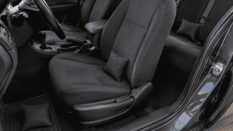 Three small activated charcoal odor absorber bags placed on car seats and in the footwell to absorb persistent smoke and mildew odors