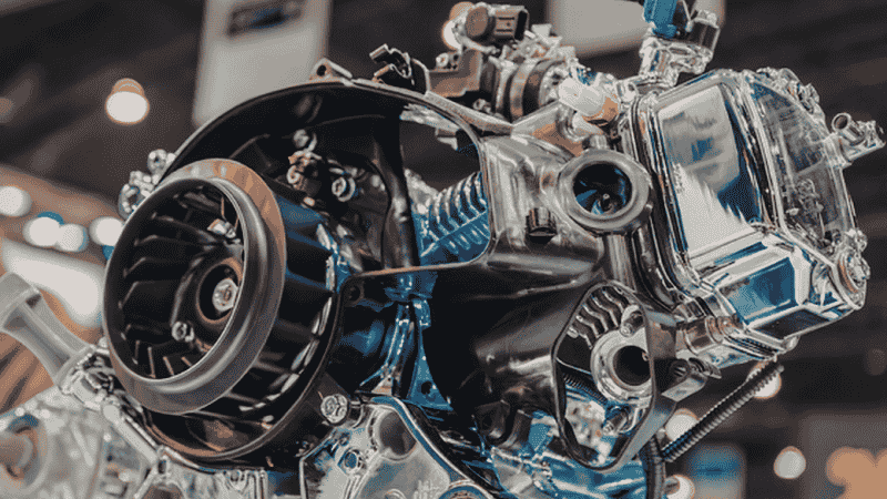 A high-resolution view of a modern turbocharged engine bay, showing the turbocharger heat shield and oil feed lines.