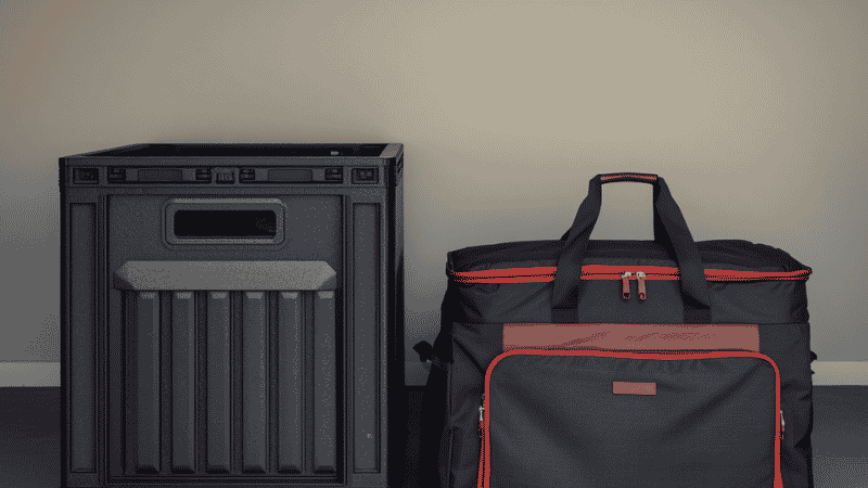Side-by-side view of a heavy-duty rigid storage crate and a collapsed soft-sided trunk bag for scale.